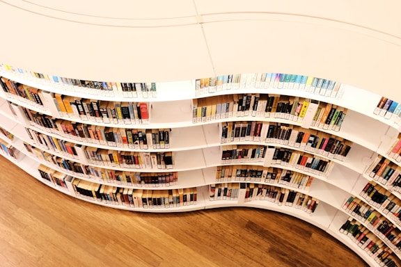 A curved book shelf filled with lots of books