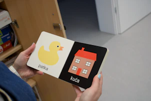 A person holding a book with a picture of a house on it