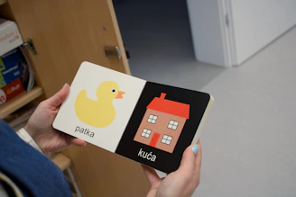 A person holding a book with a picture of a house on it