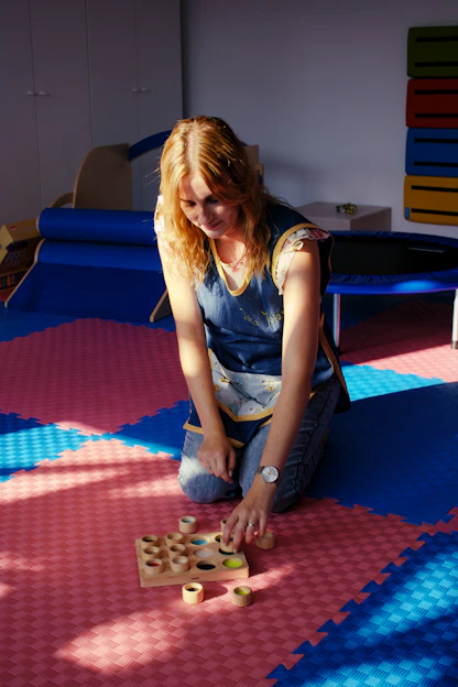 A woman sitting on the floor playing with a wooden block