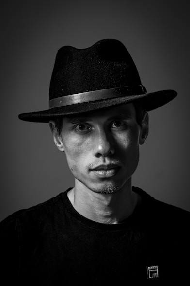 A man wearing a hat and a black shirt