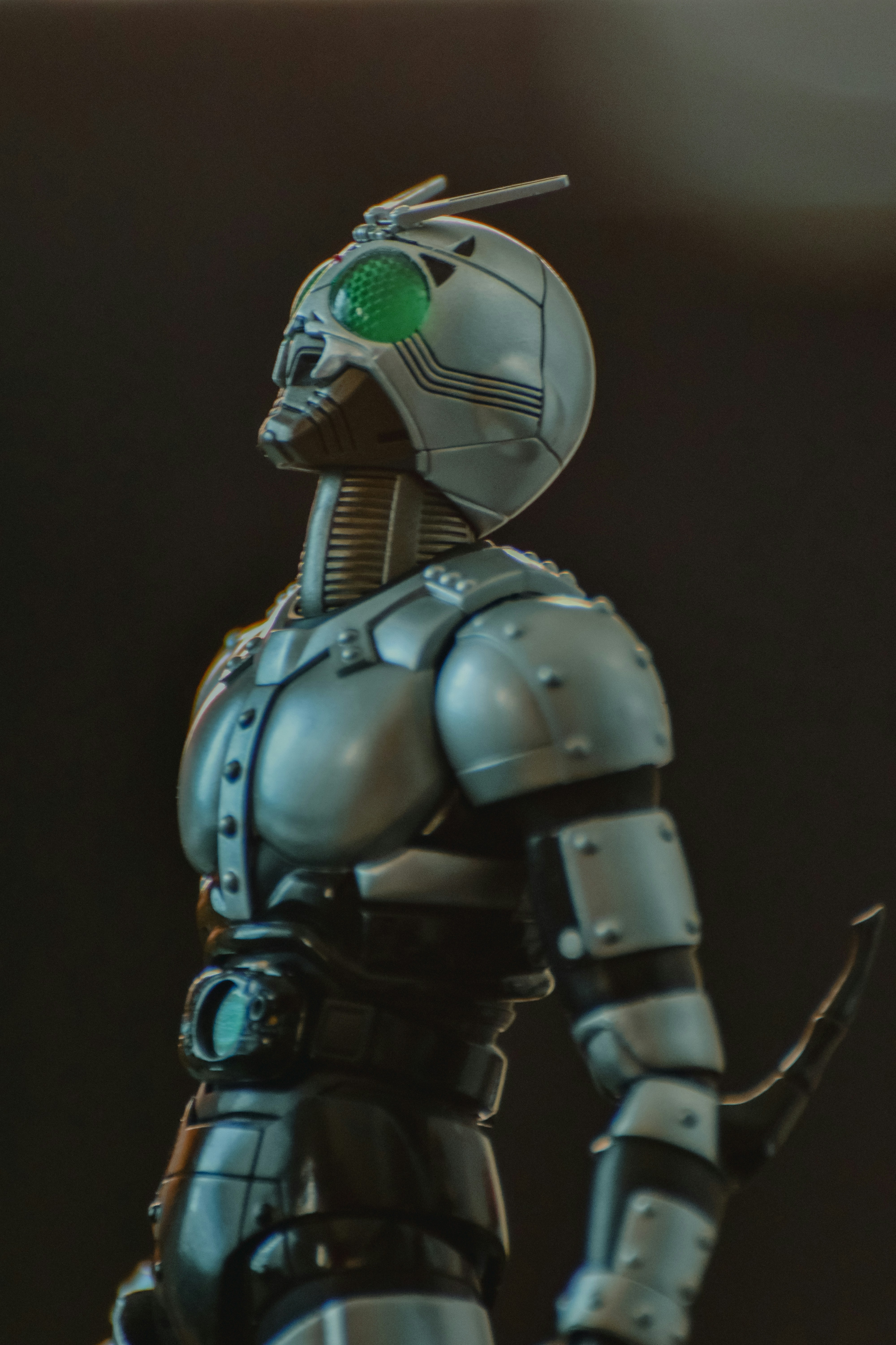 A robot with a green eye standing in front of a black background