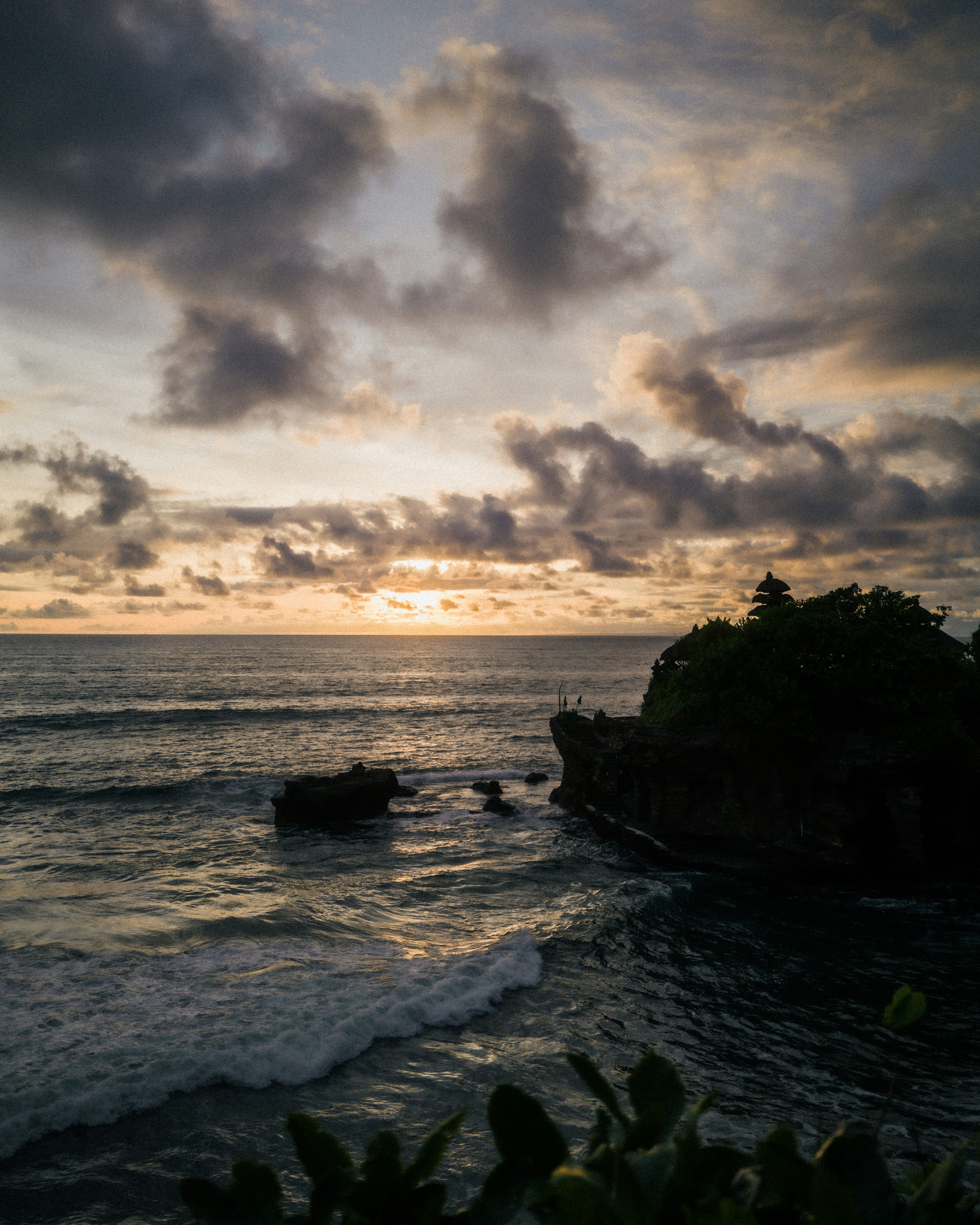 Die Sonne geht über dem Ozean unter, mit einer kleinen Insel im Vordergrund