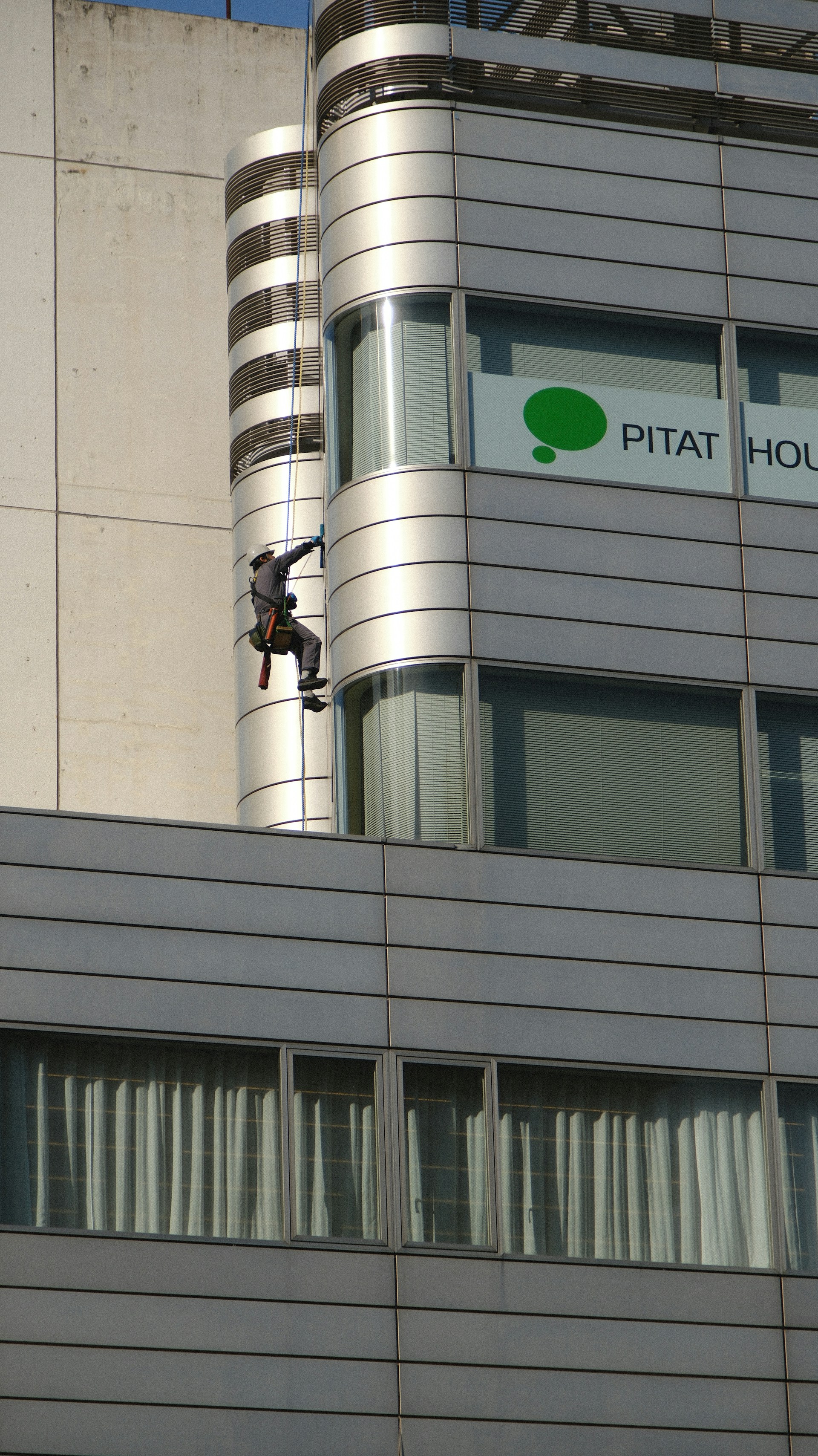 A man on a rope on the side of a building