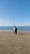 A man sitting on top of a sandy beach next to the ocean