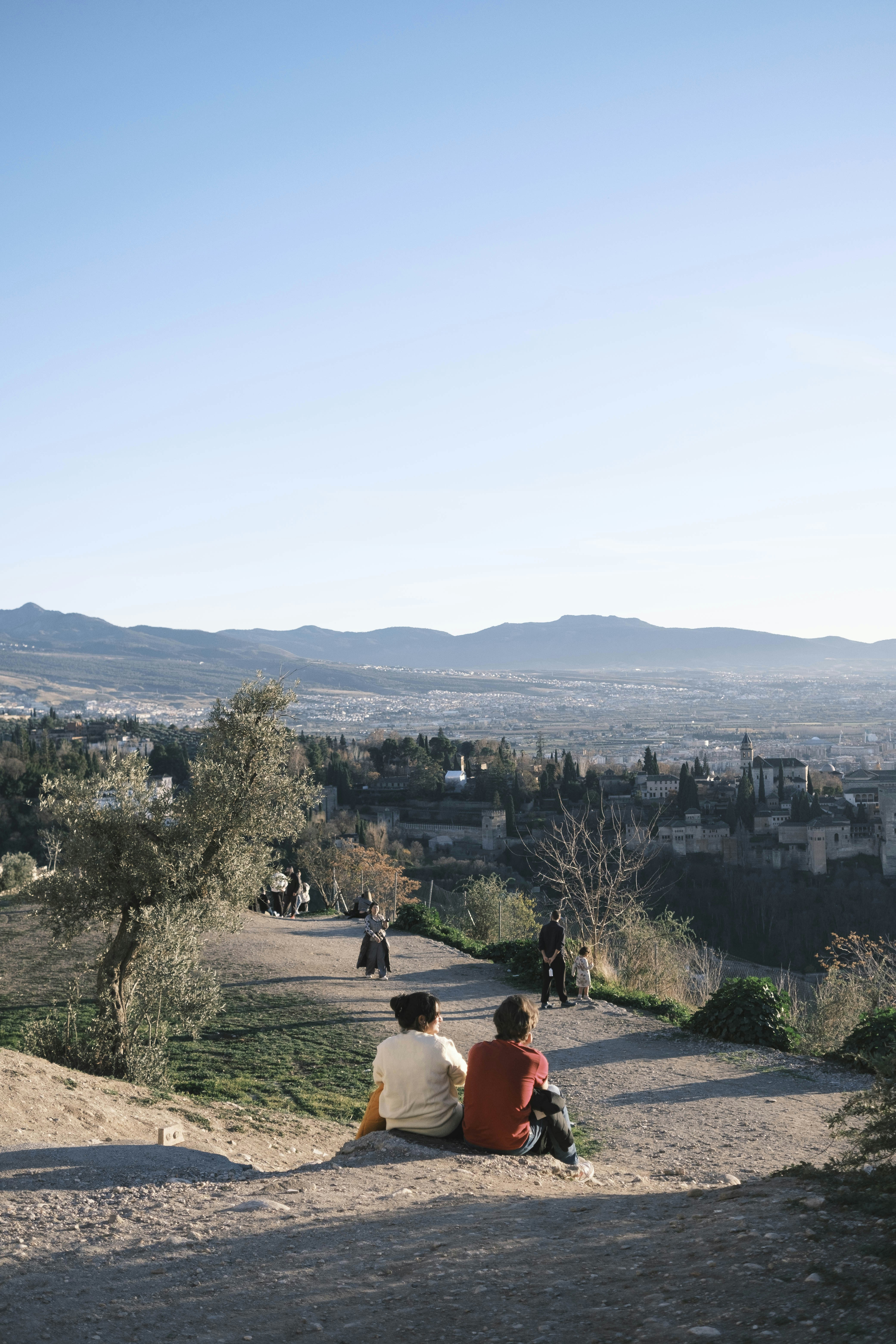A couple of people sitting on top of a hill