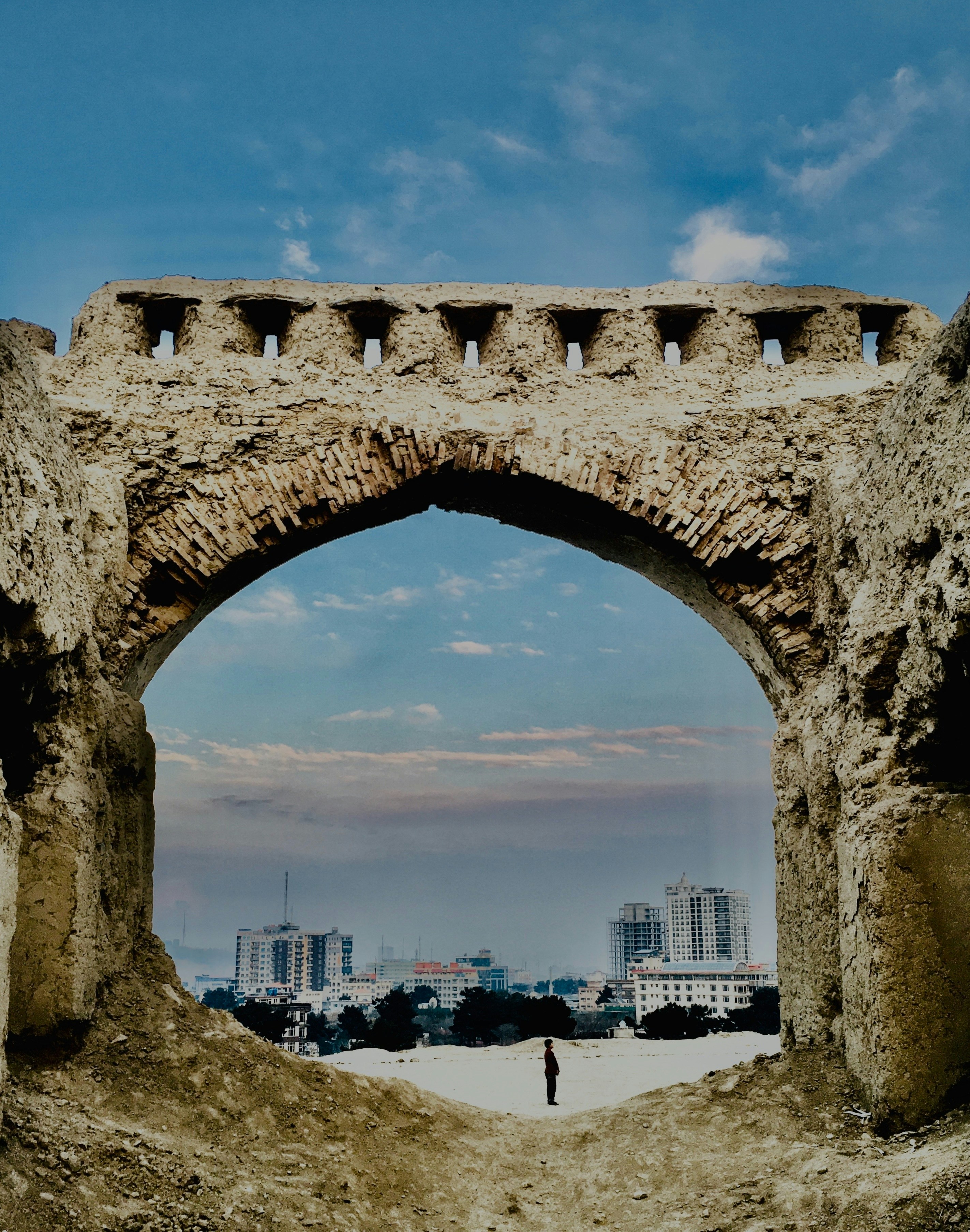 Ein steinerner Bogen, in dessen Mitte ein Mann steht