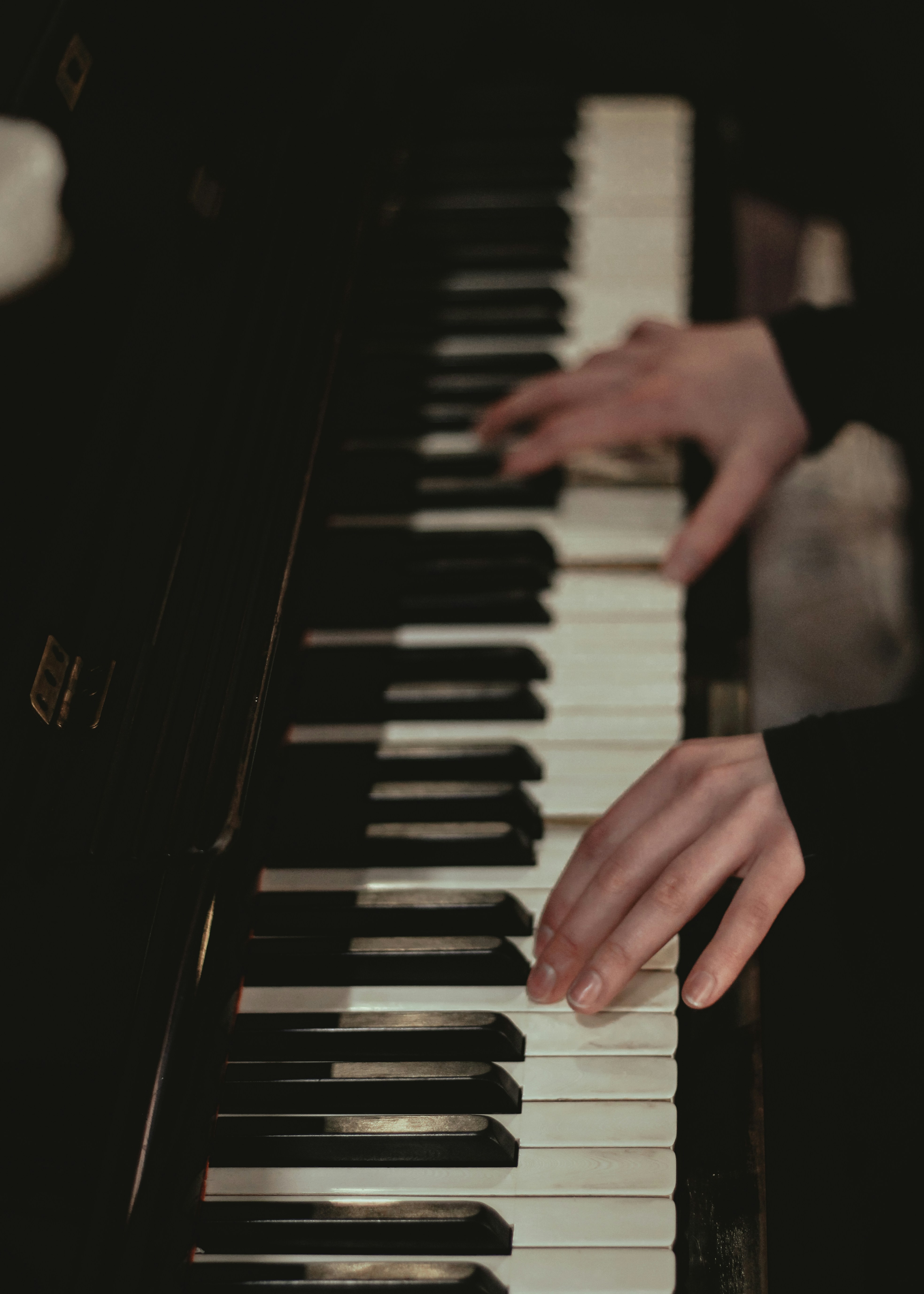 A person playing a piano in a dark room