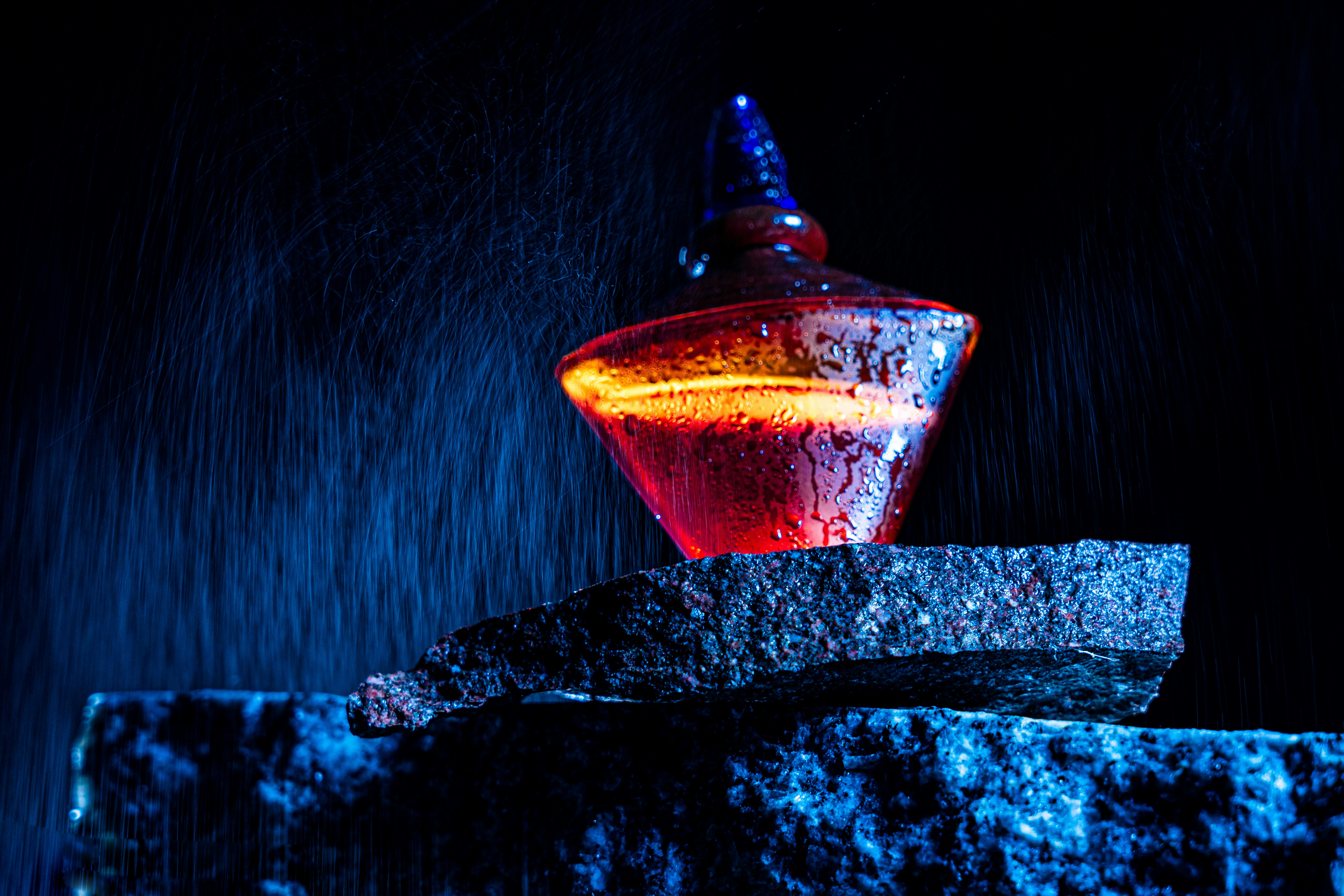 A glass bottle sitting on top of a rock
