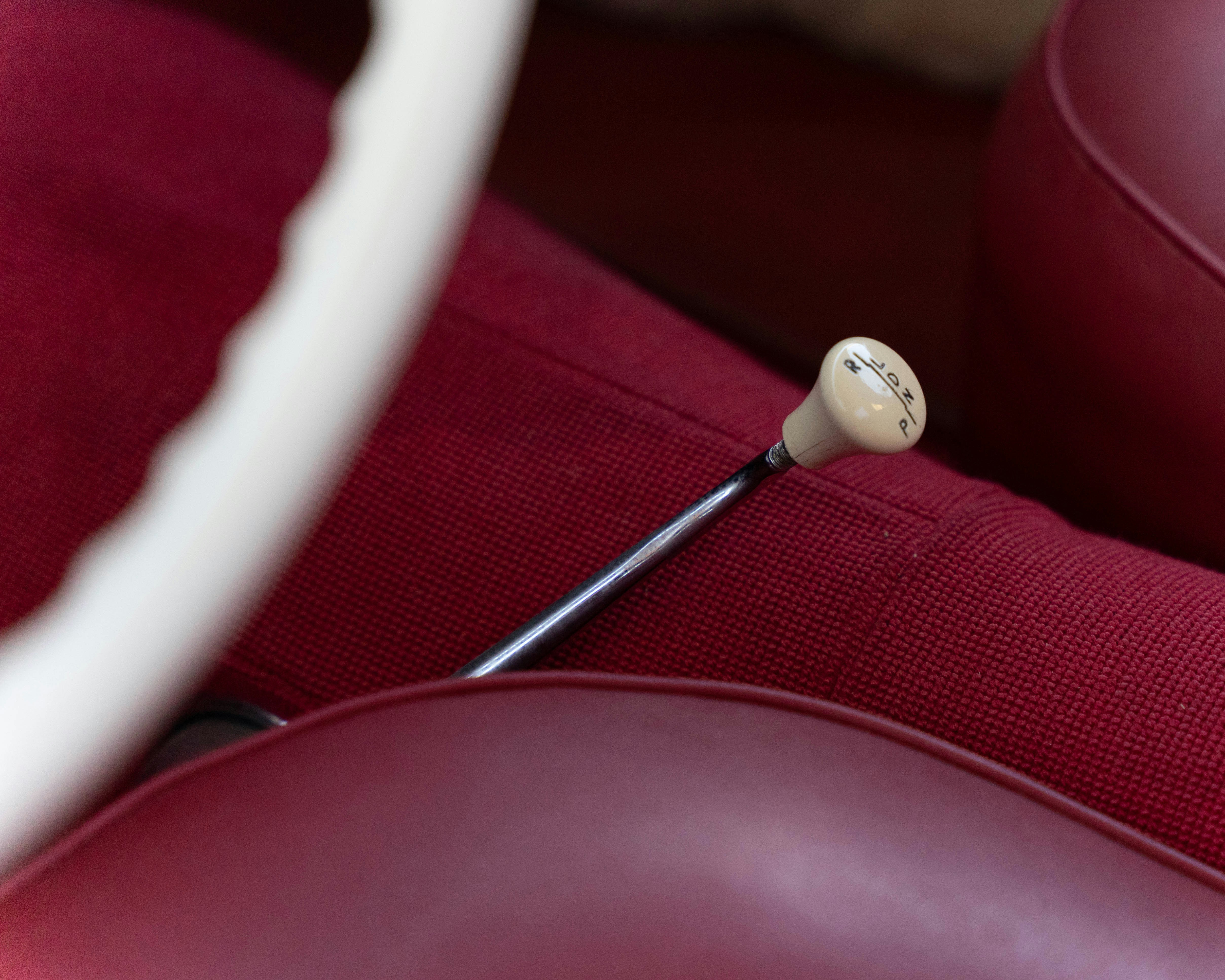 A close up of a red leather chair with a white handle