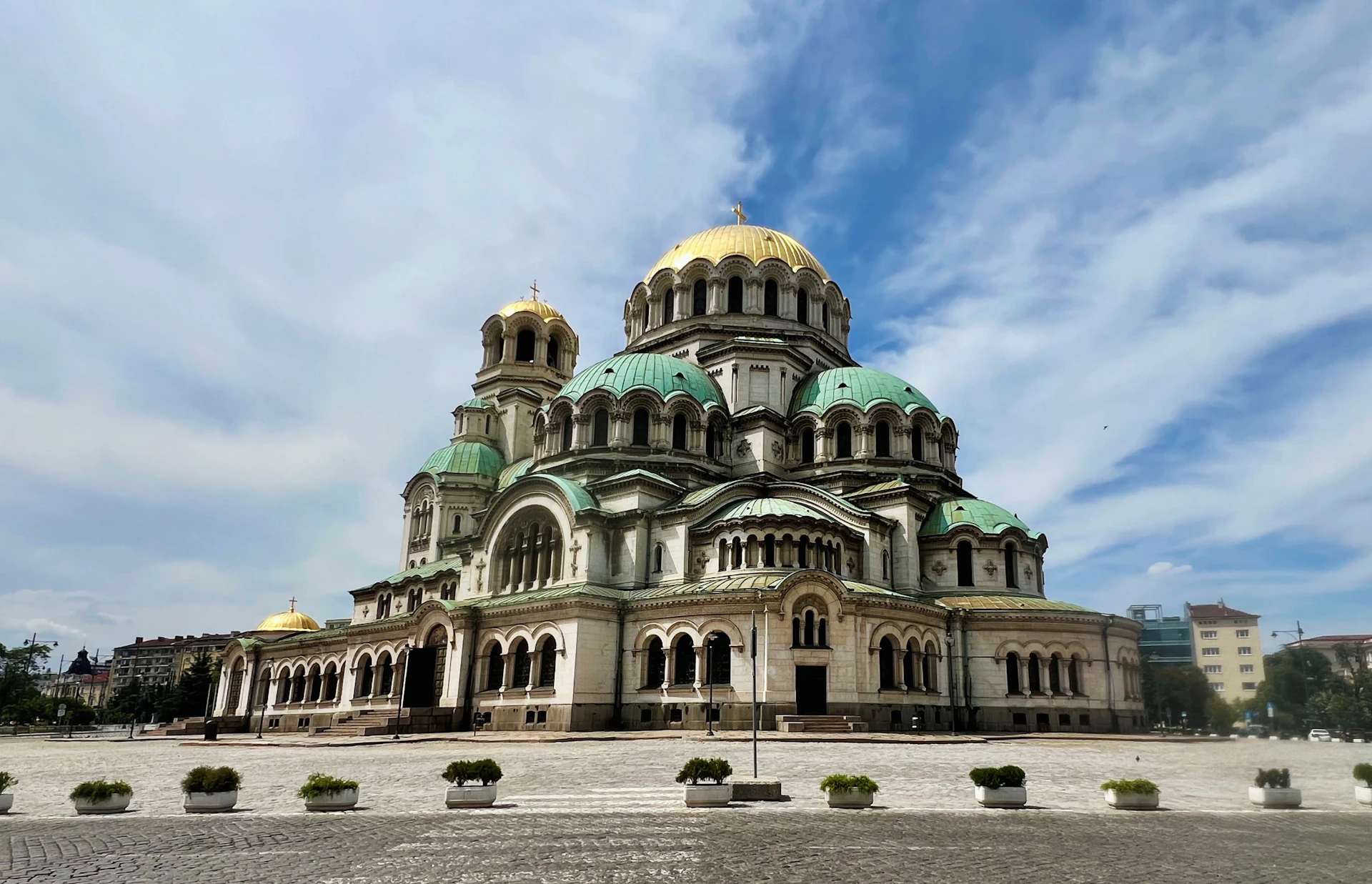 A large building with a green roof and gold domes