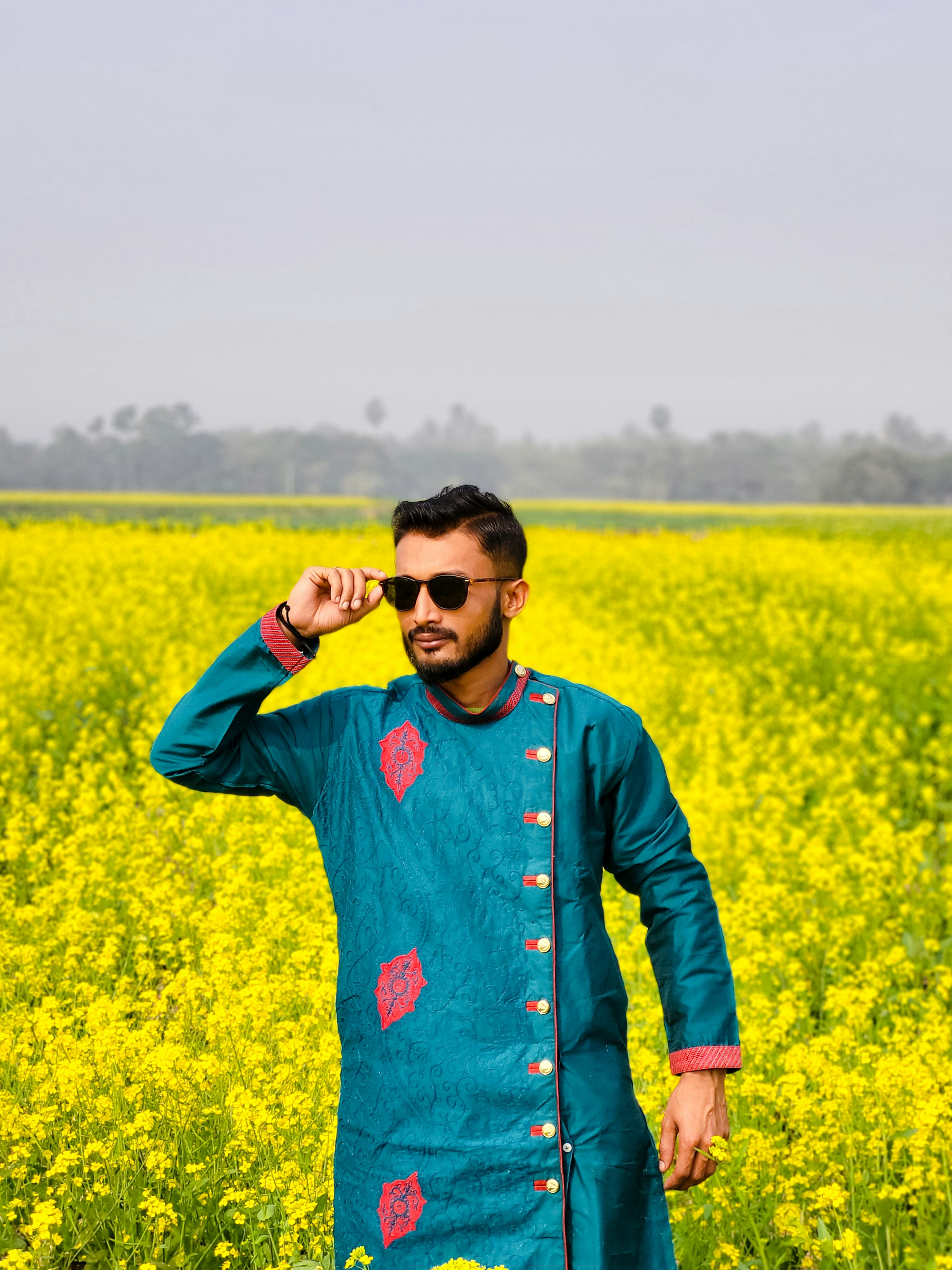 Ein Mann steht in einem Feld mit gelben Blumen