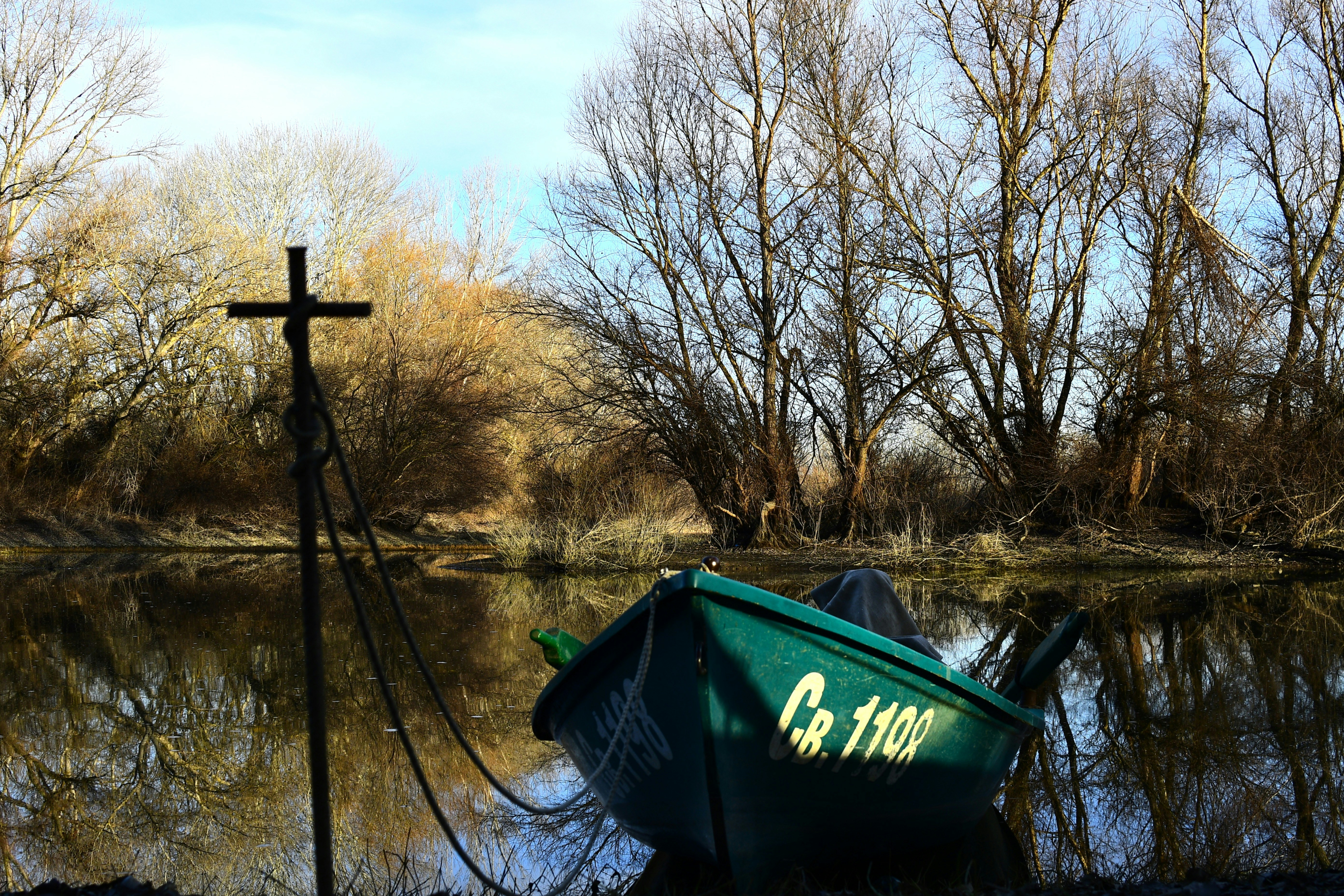 A green boat sitting on top of a lake