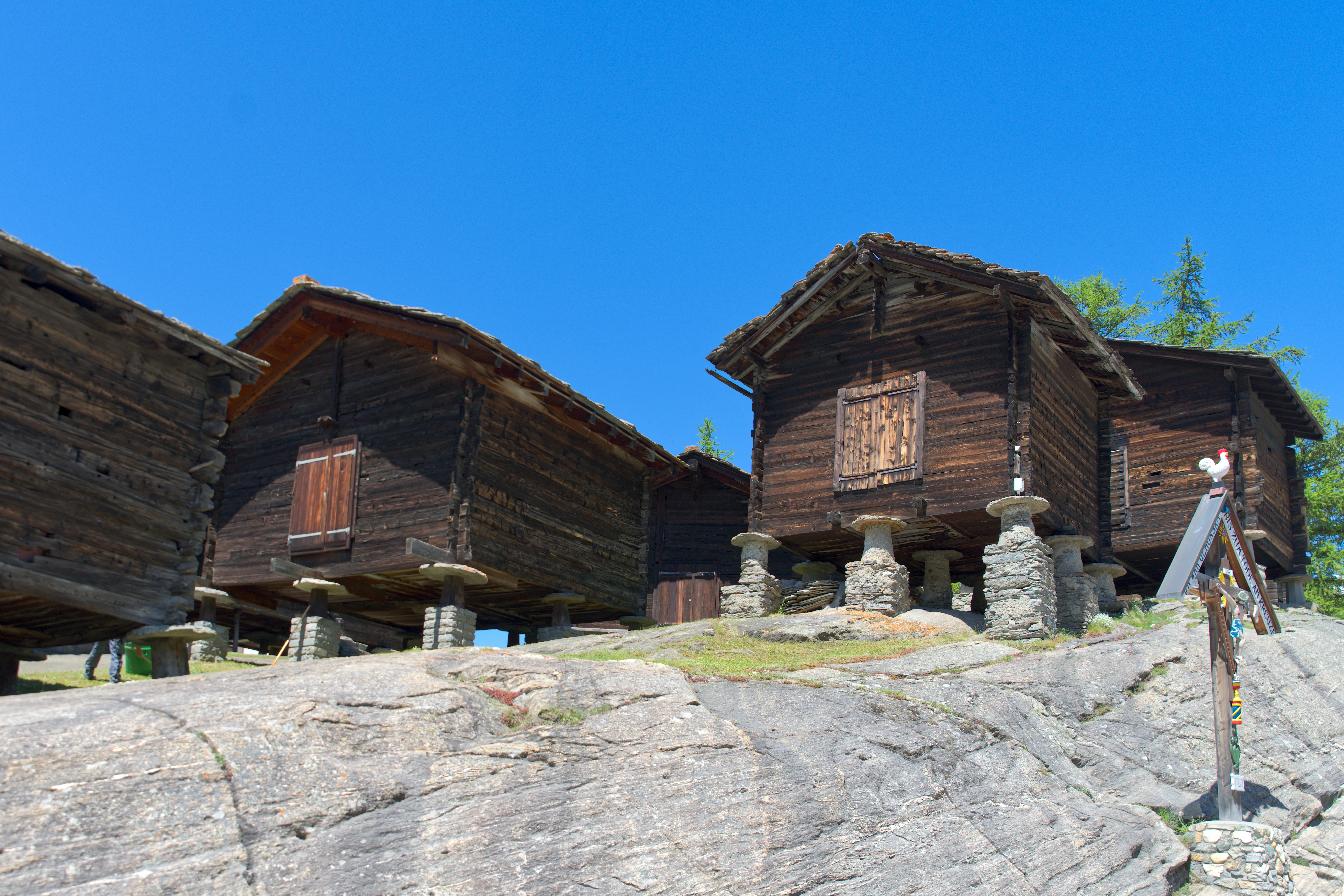 A group of wooden buildings sitting on top of a rocky hillside