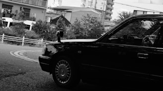 A black and white photo of a car parked on the side of the road