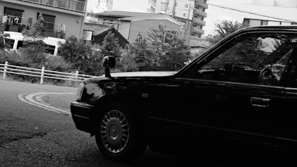 A black and white photo of a car parked on the side of the road