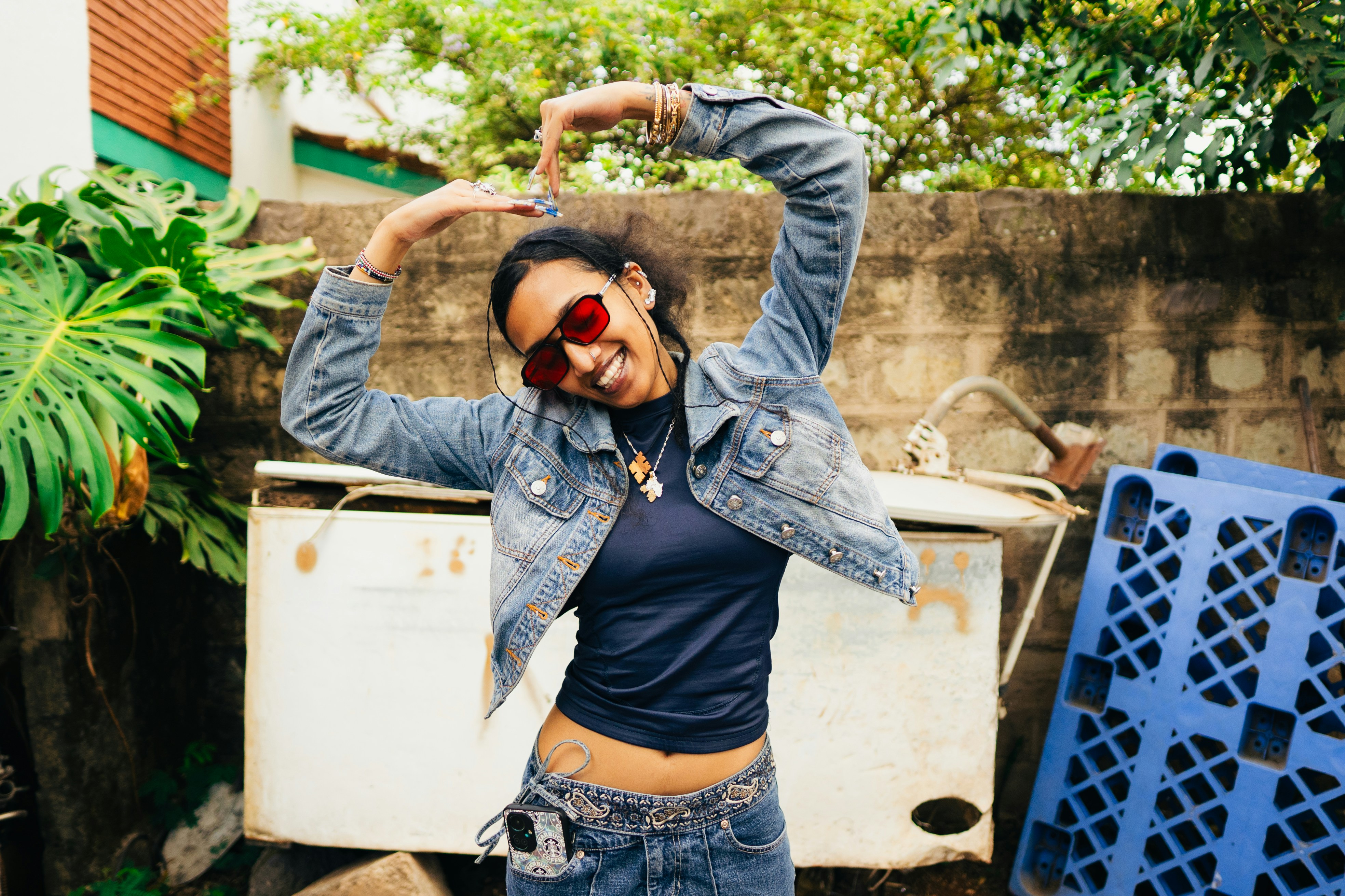 A man wearing a jean jacket and sunglasses
