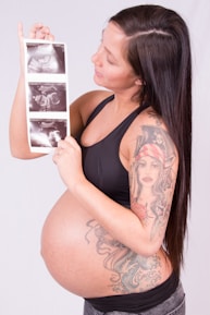 A pregnant woman holding up a picture of herself