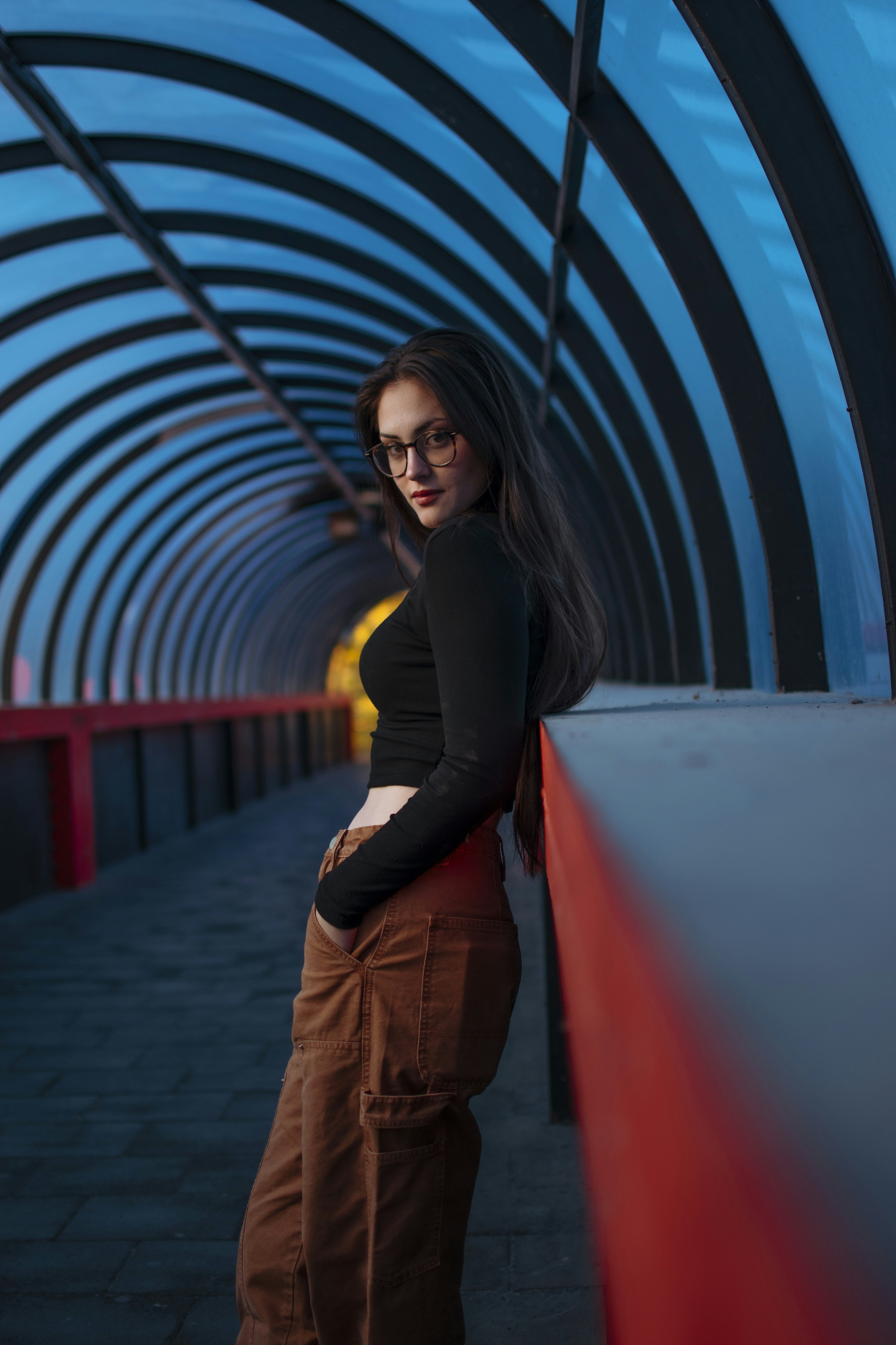 Uma mulher encostada em uma parede em um túnel