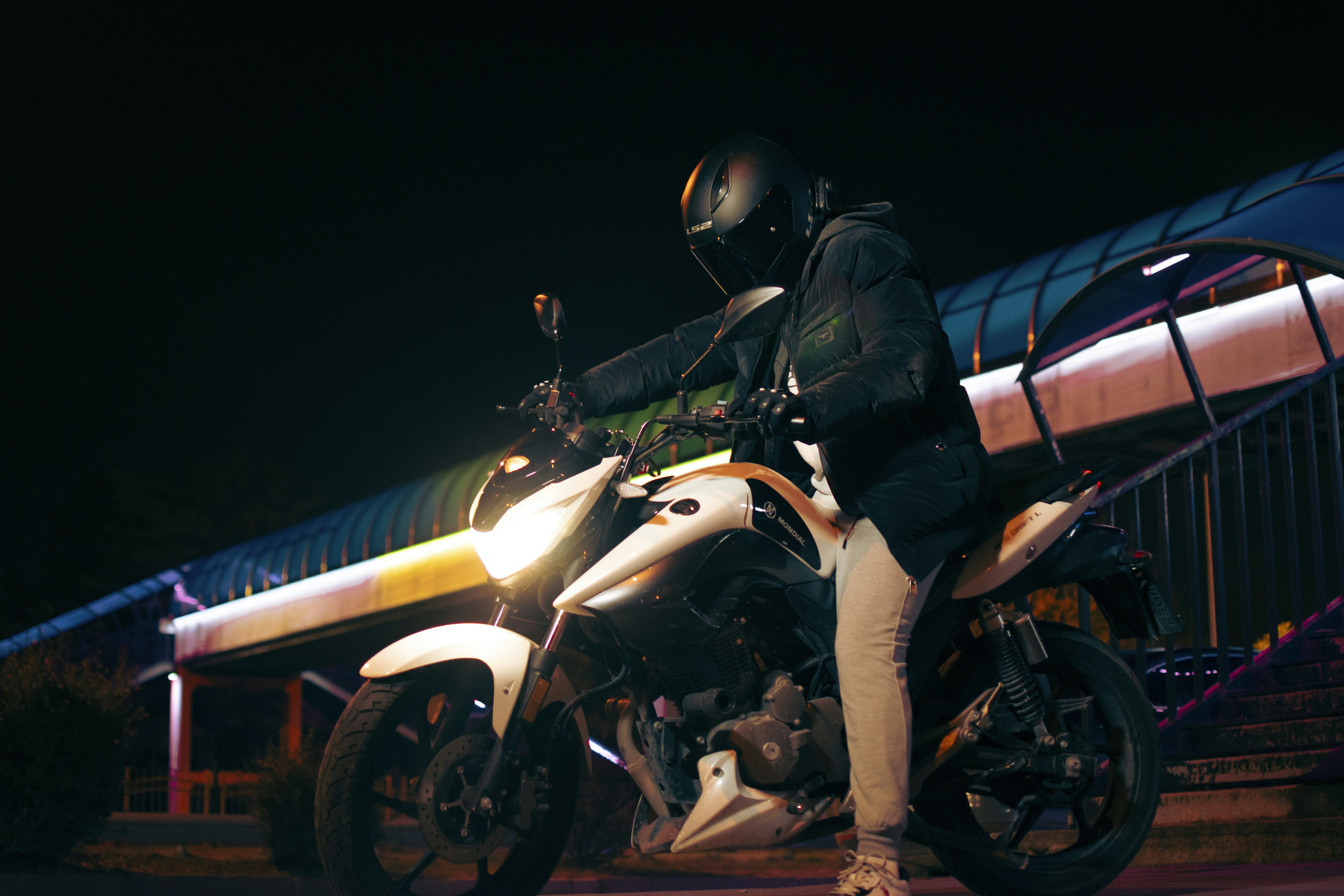 A man riding a motorcycle at night on a street