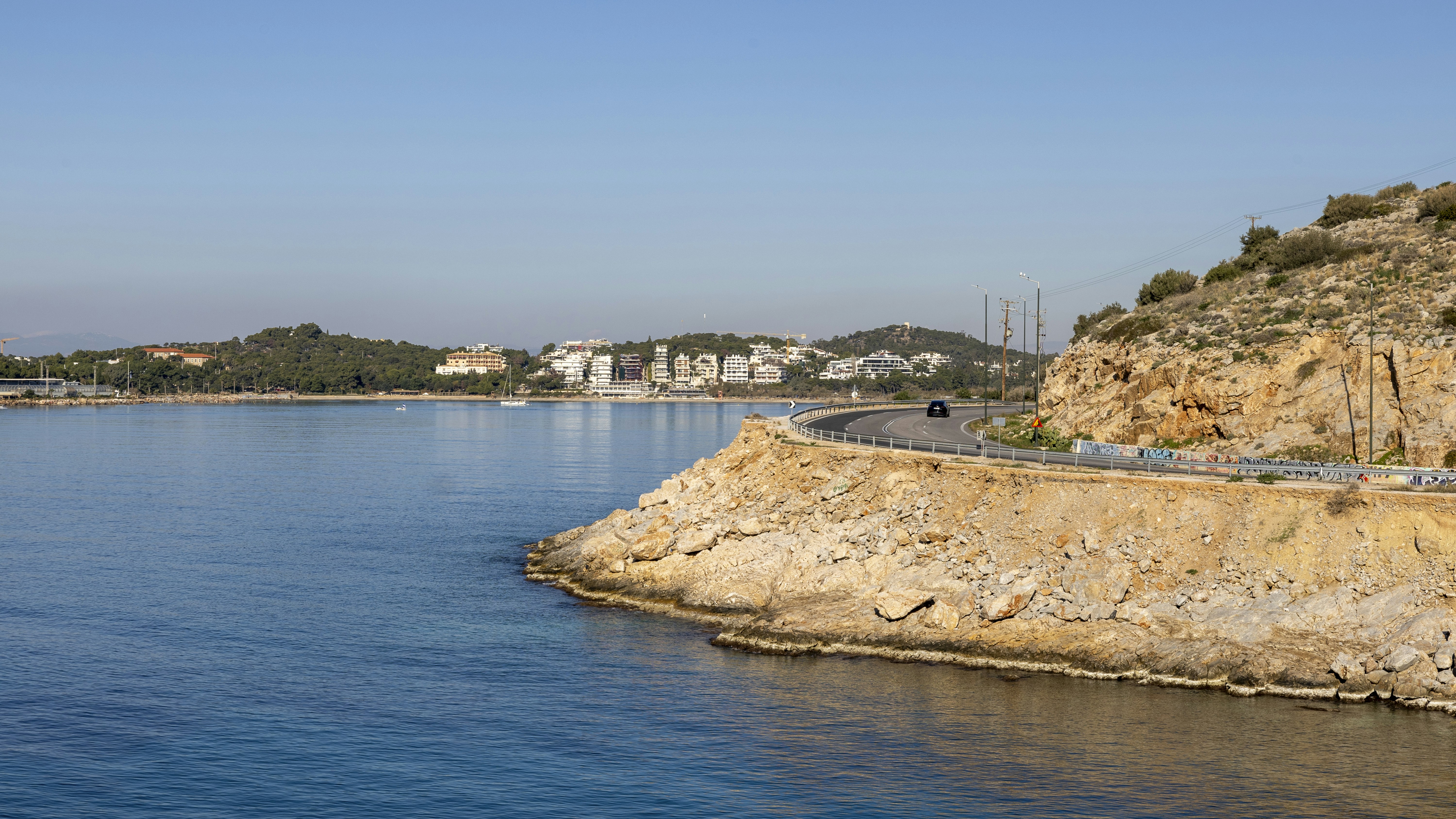 A body of water with a hill in the background