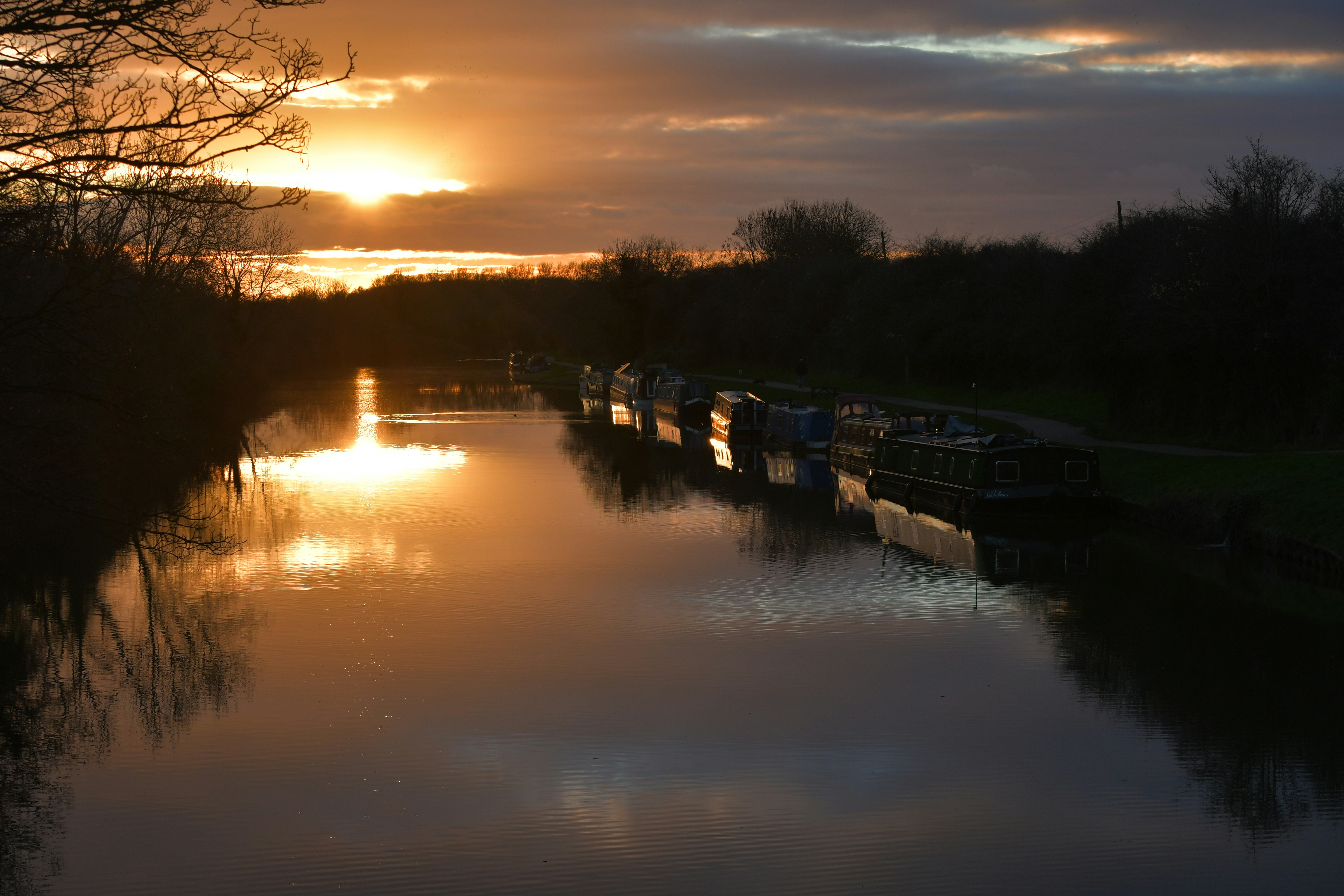 The sun is setting over the water of a canal