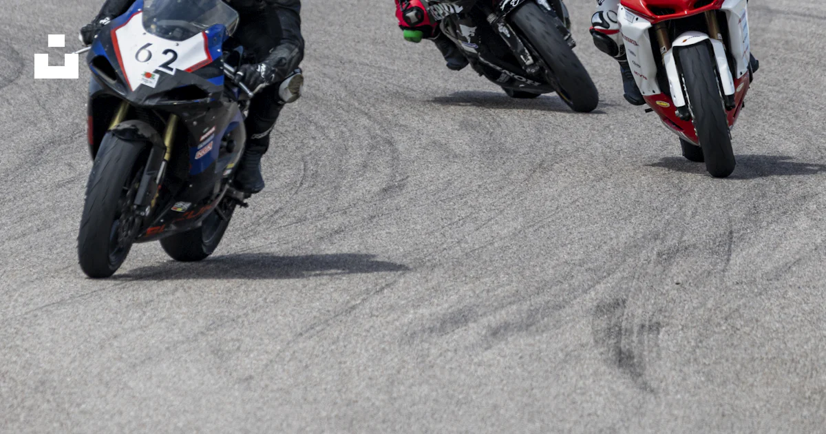 A group of motorcyclists racing around a track photo – Free Circuit de ...