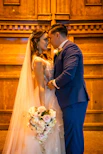 A bride and groom standing in front of a church alter
