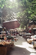 An outdoor market with umbrellas and baskets of food