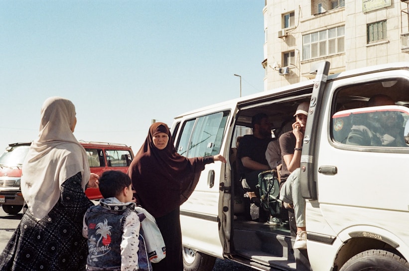 A group of people standing next to a white van