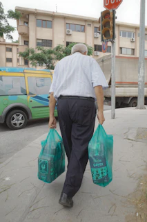 A man walking down the street carrying bags
