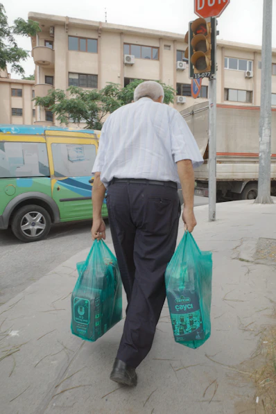 A man walking down the street carrying bags