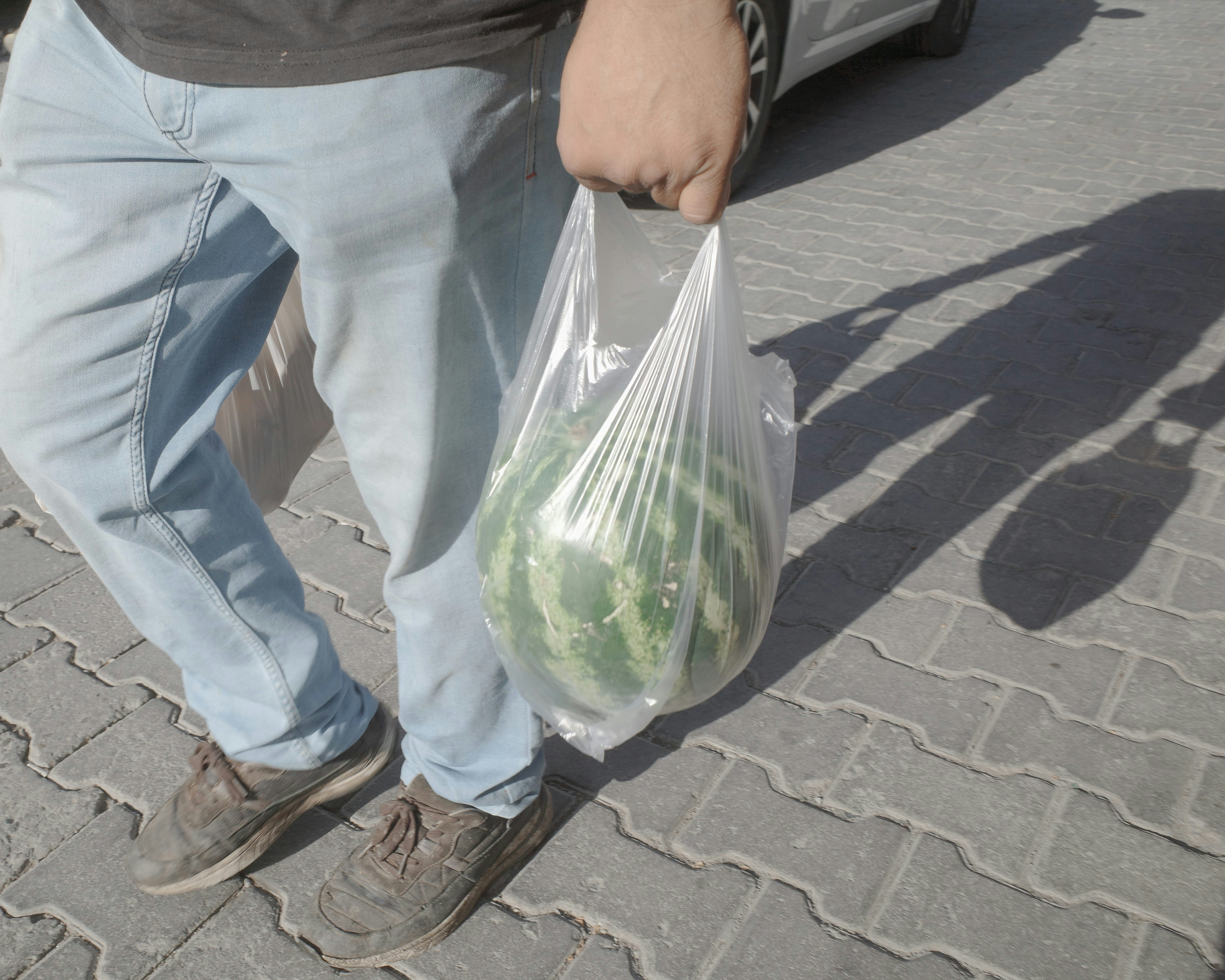 Man carrying a plastic bag of vegetables