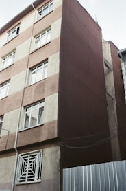 A tall brown building with lots of windows