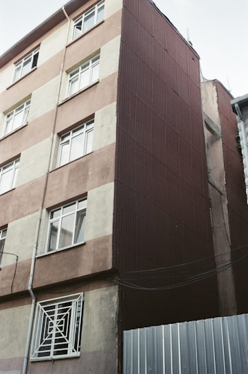 A tall brown building with lots of windows