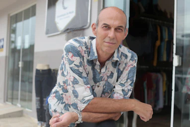 A man leaning against a glass door in front of a store