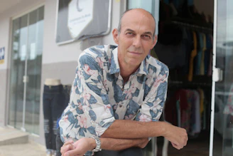 A man leaning against a glass door in front of a store