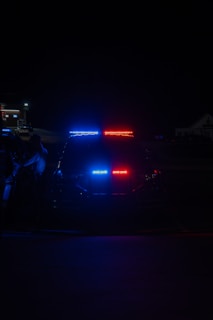 A police car parked on the side of the road at night