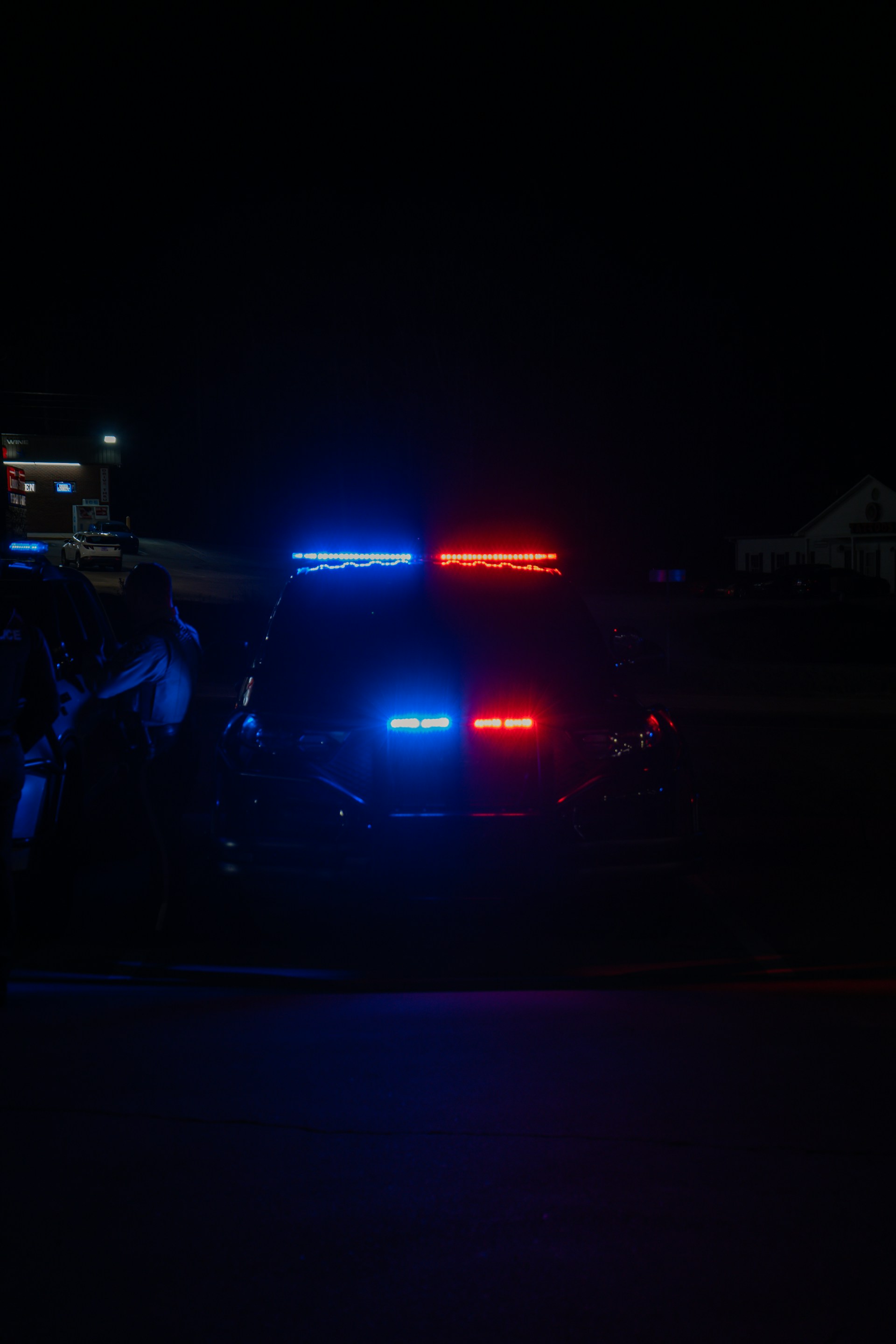 A police car parked on the side of the road at night