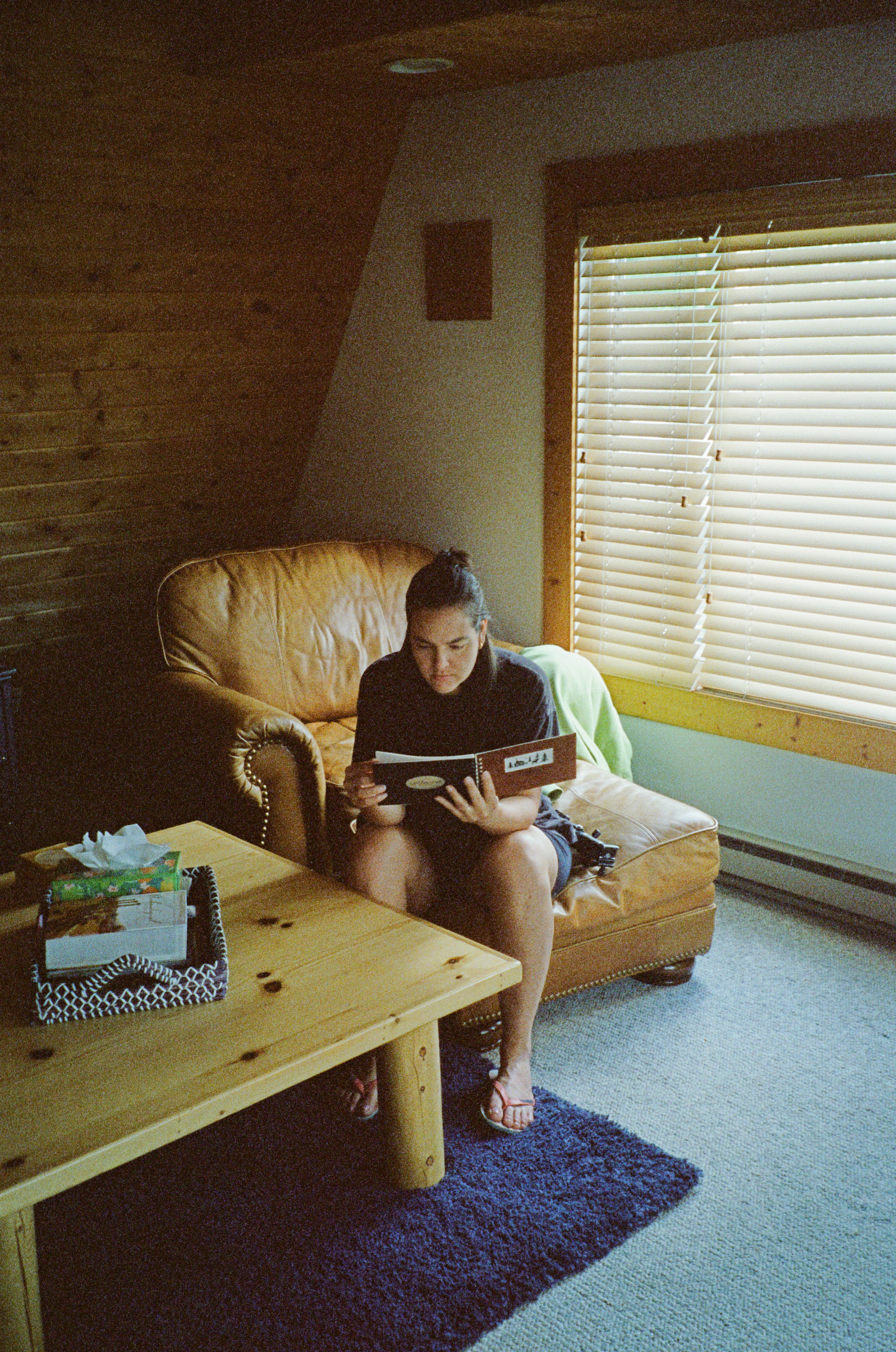A woman sitting on a couch reading a book