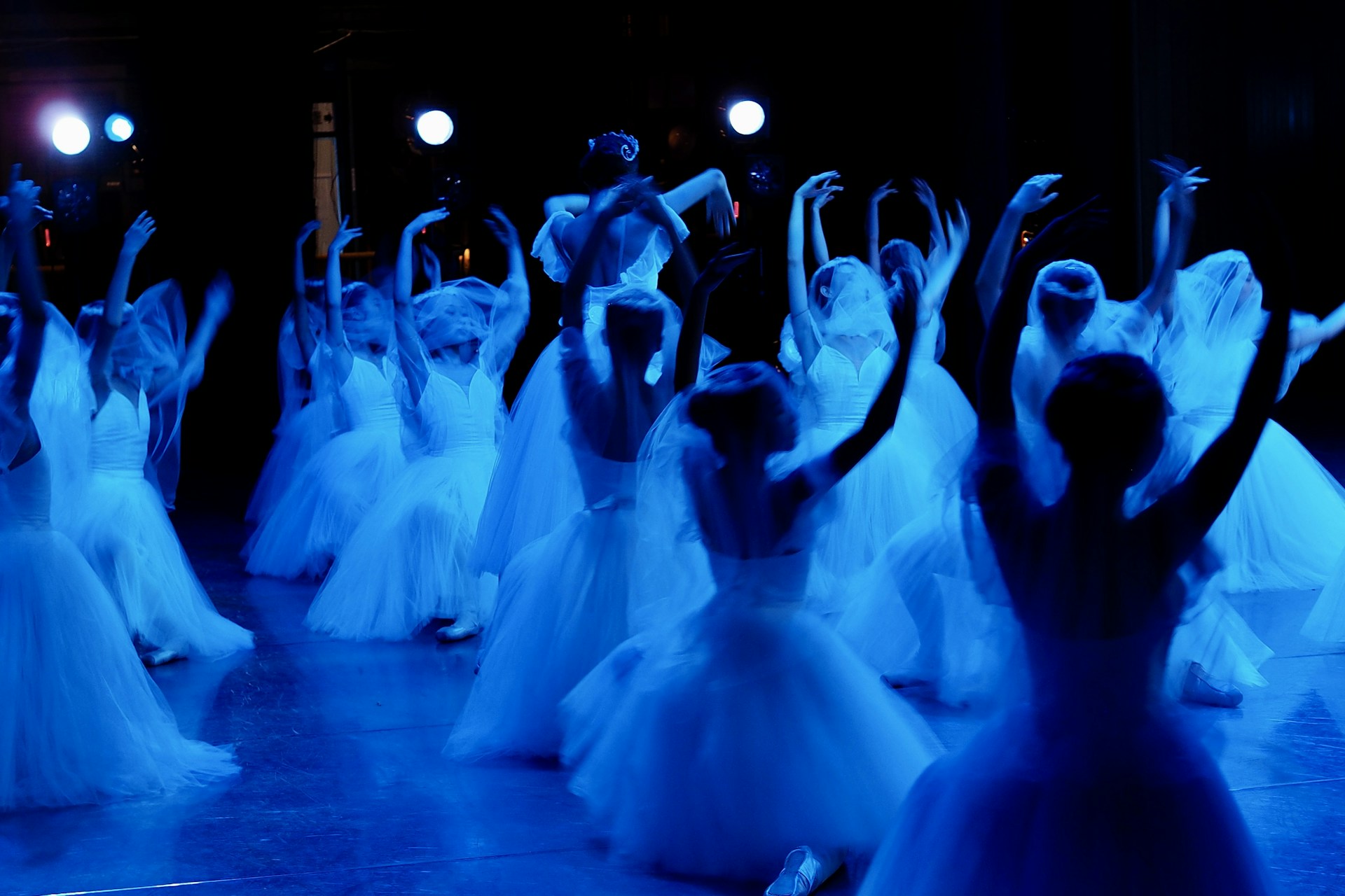 A group of people dressed in white dancing on a stage