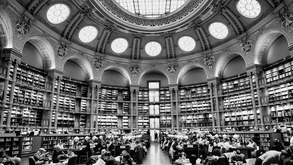 Grand domed public reading room with bookshelves and shared tables