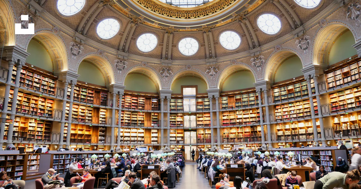 A large library filled with lots of books photo – Free Human Image on ...