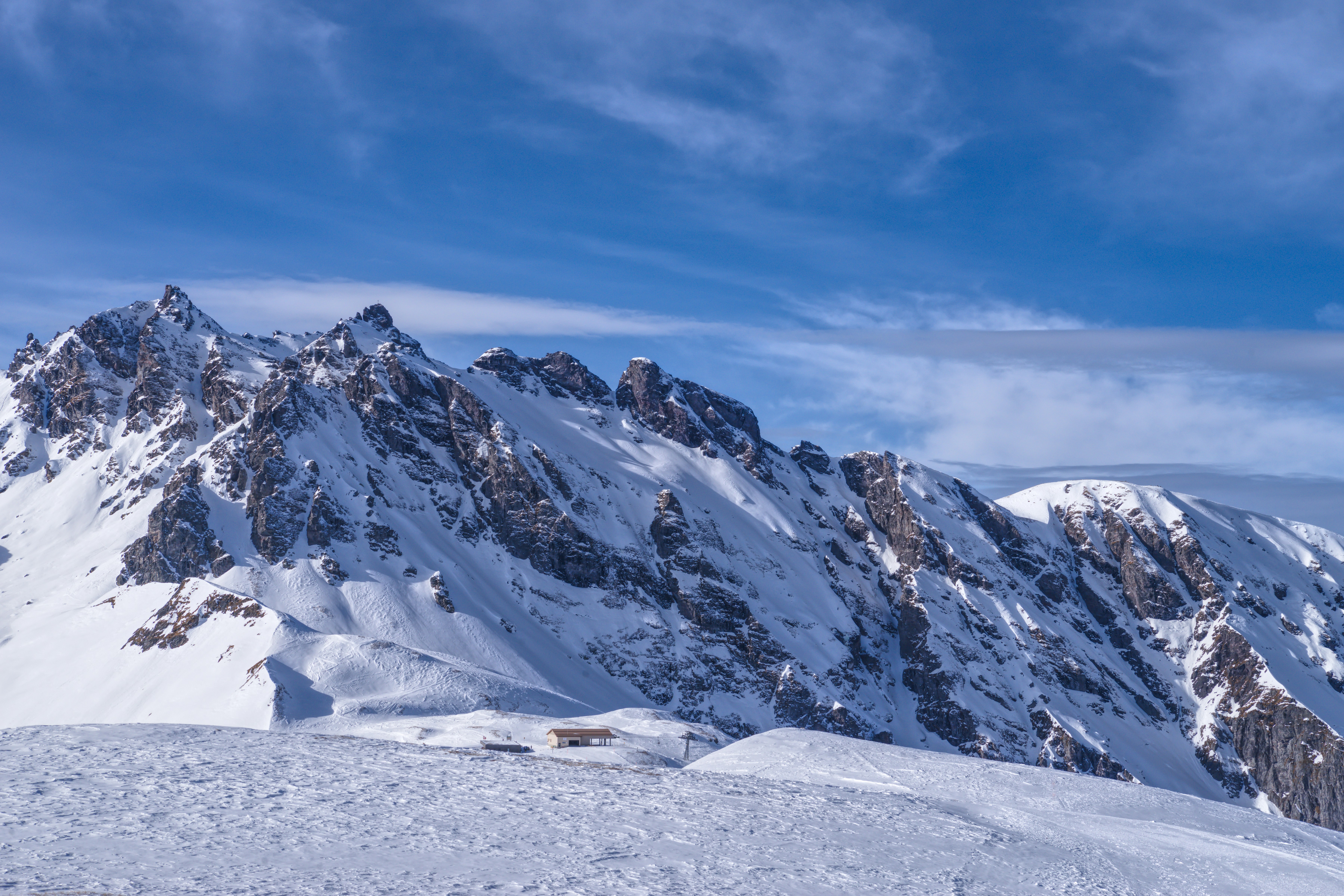 A mountain covered in snow under a blue sky