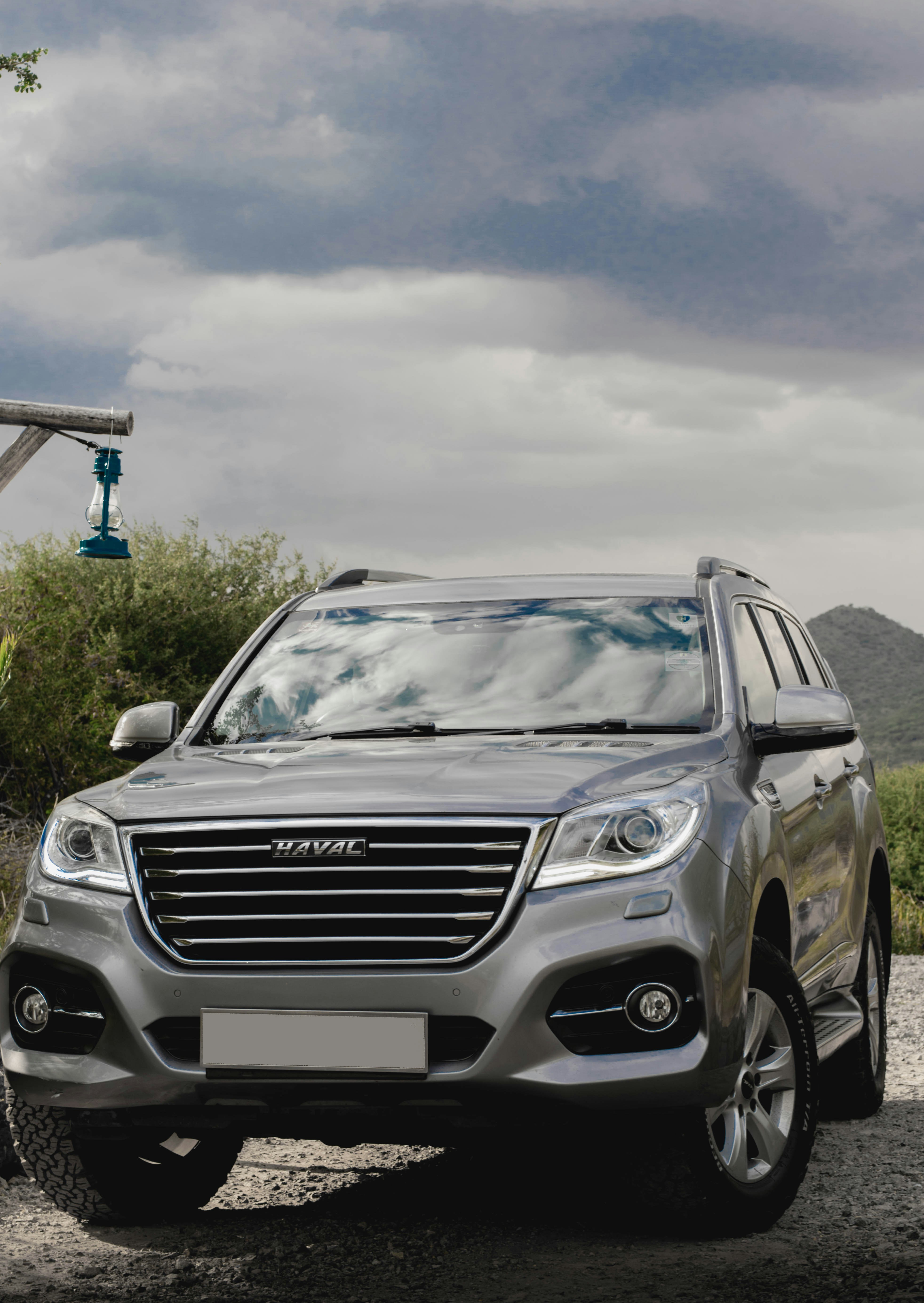 A silver suv parked on a gravel road