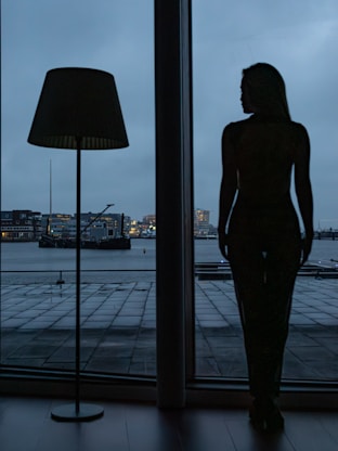 A woman standing in front of a large window