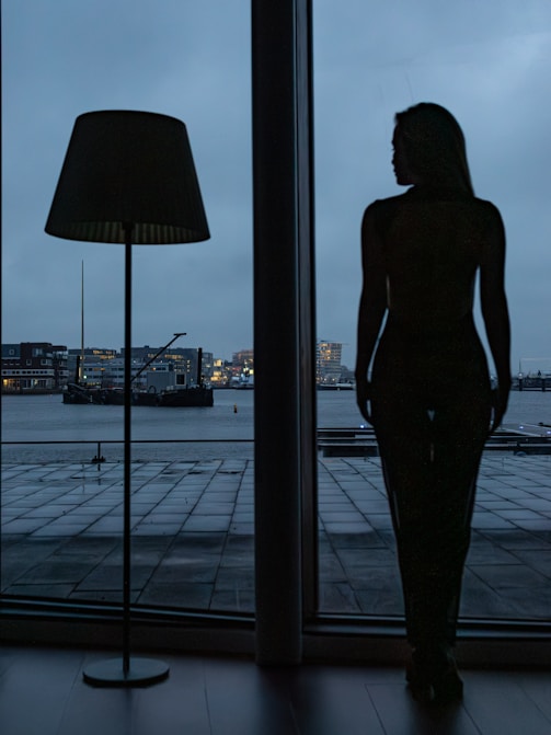 A woman standing in front of a large window
