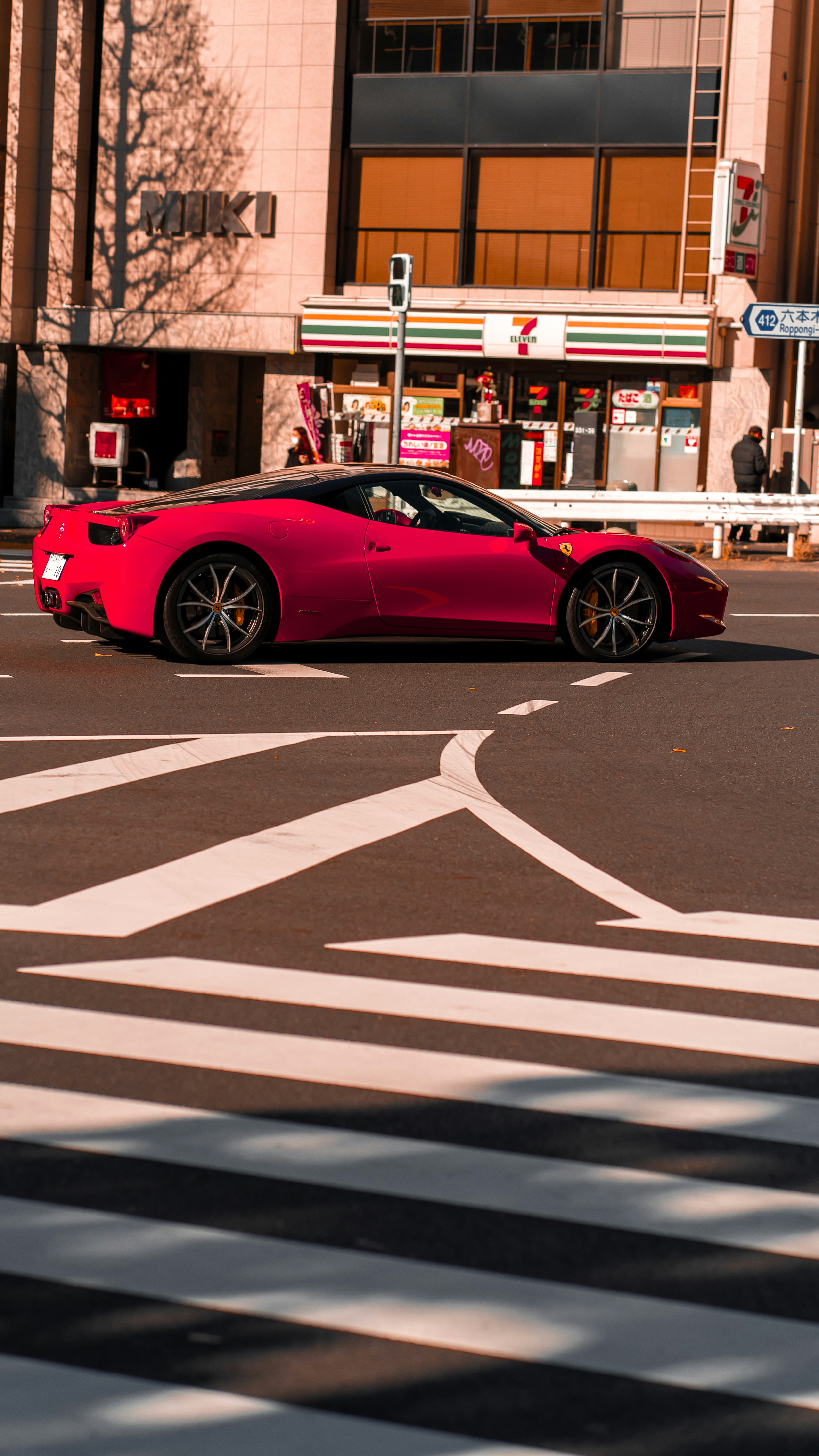 Ein roter Sportwagen, der eine Straße in der Stadt entlangfährt