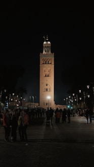 A group of people standing in front of a tall clock tower