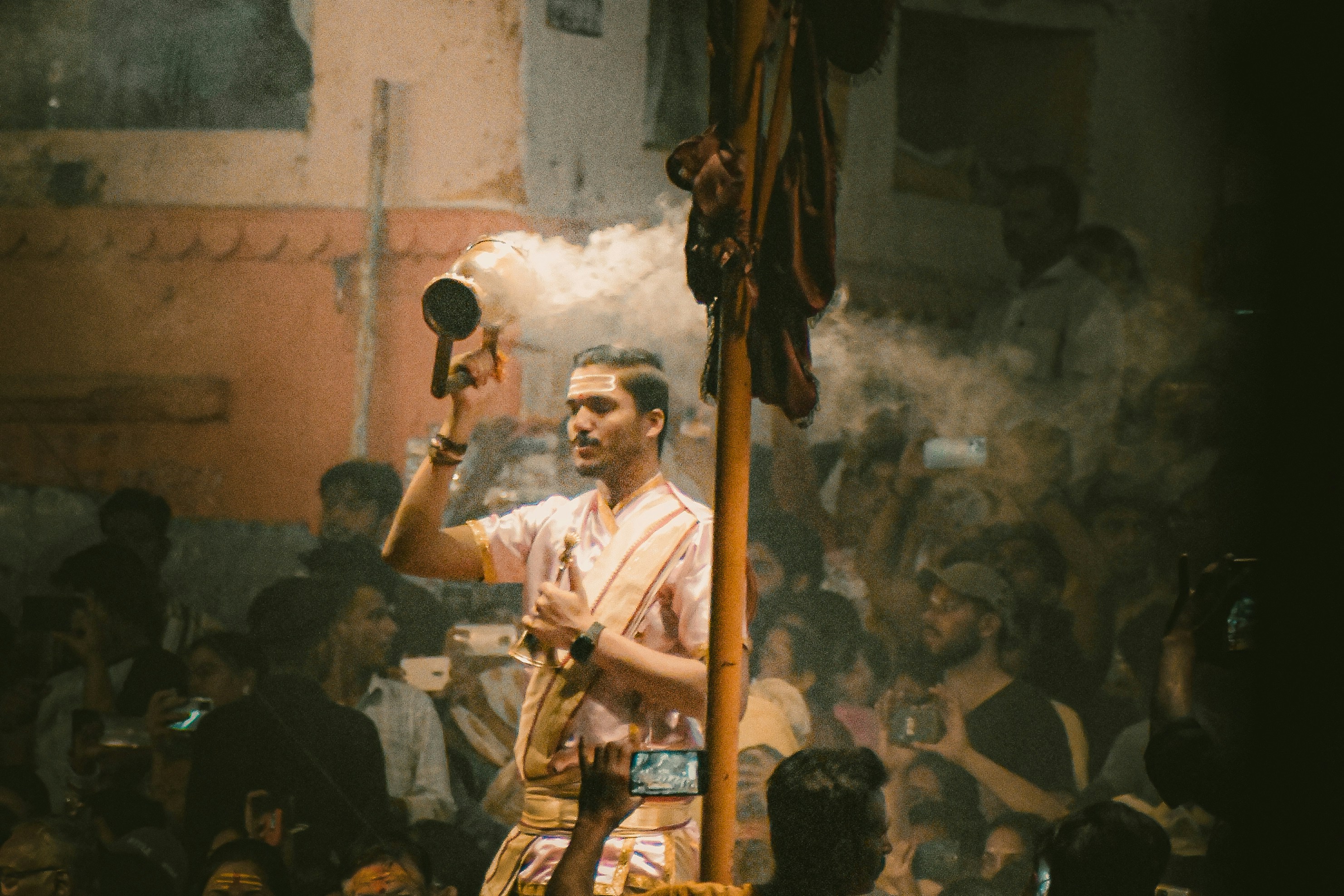 A man holding a smoke stick in front of a crowd